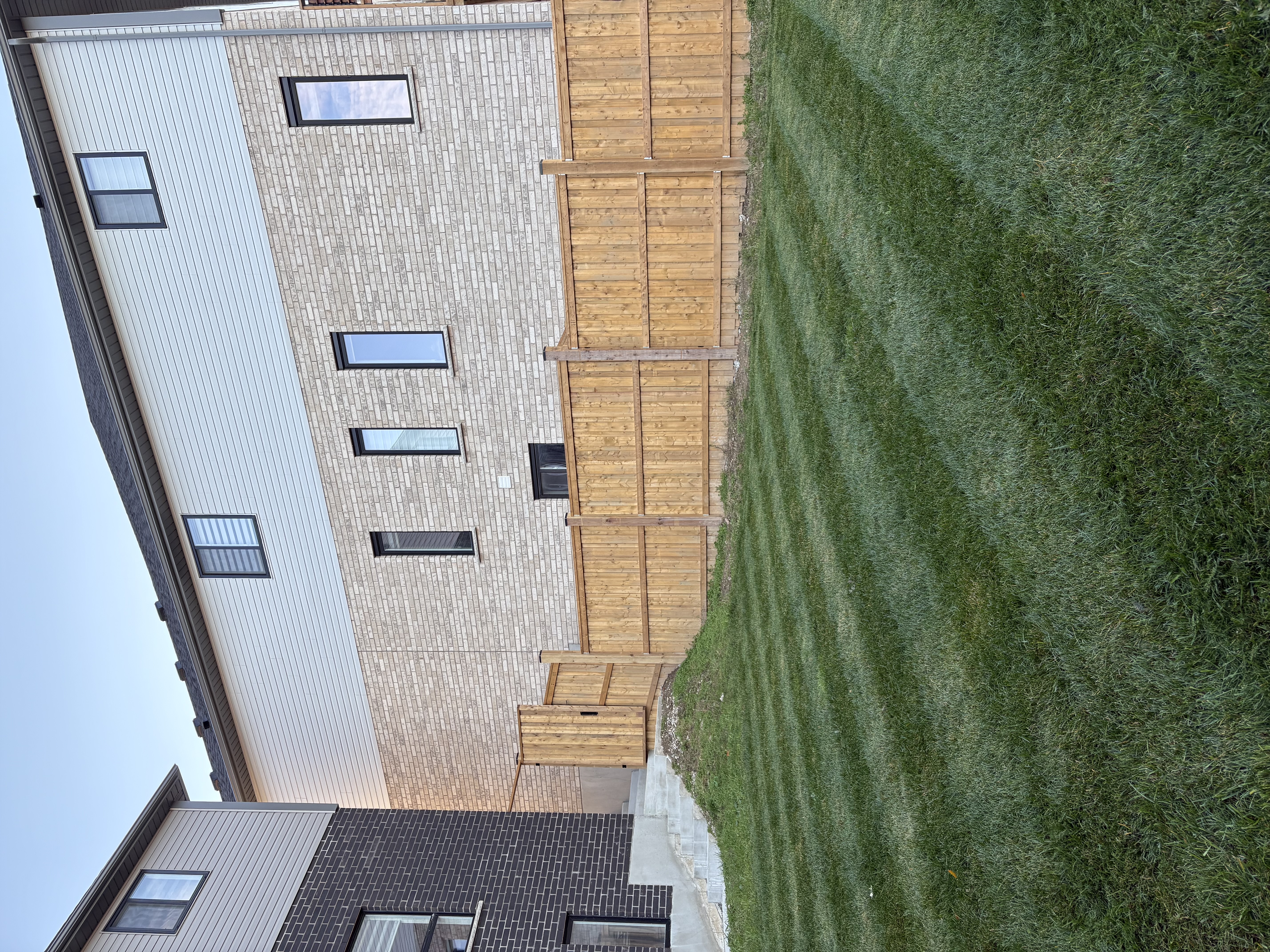 Professionally striped lawn with newly installed wooden privacy fence